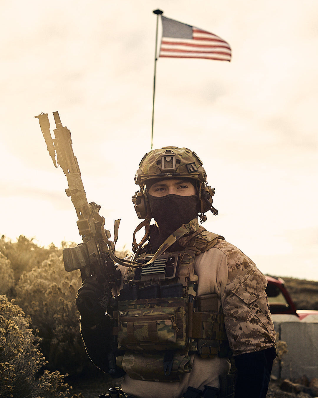 Person in military gear with an American flag in the background